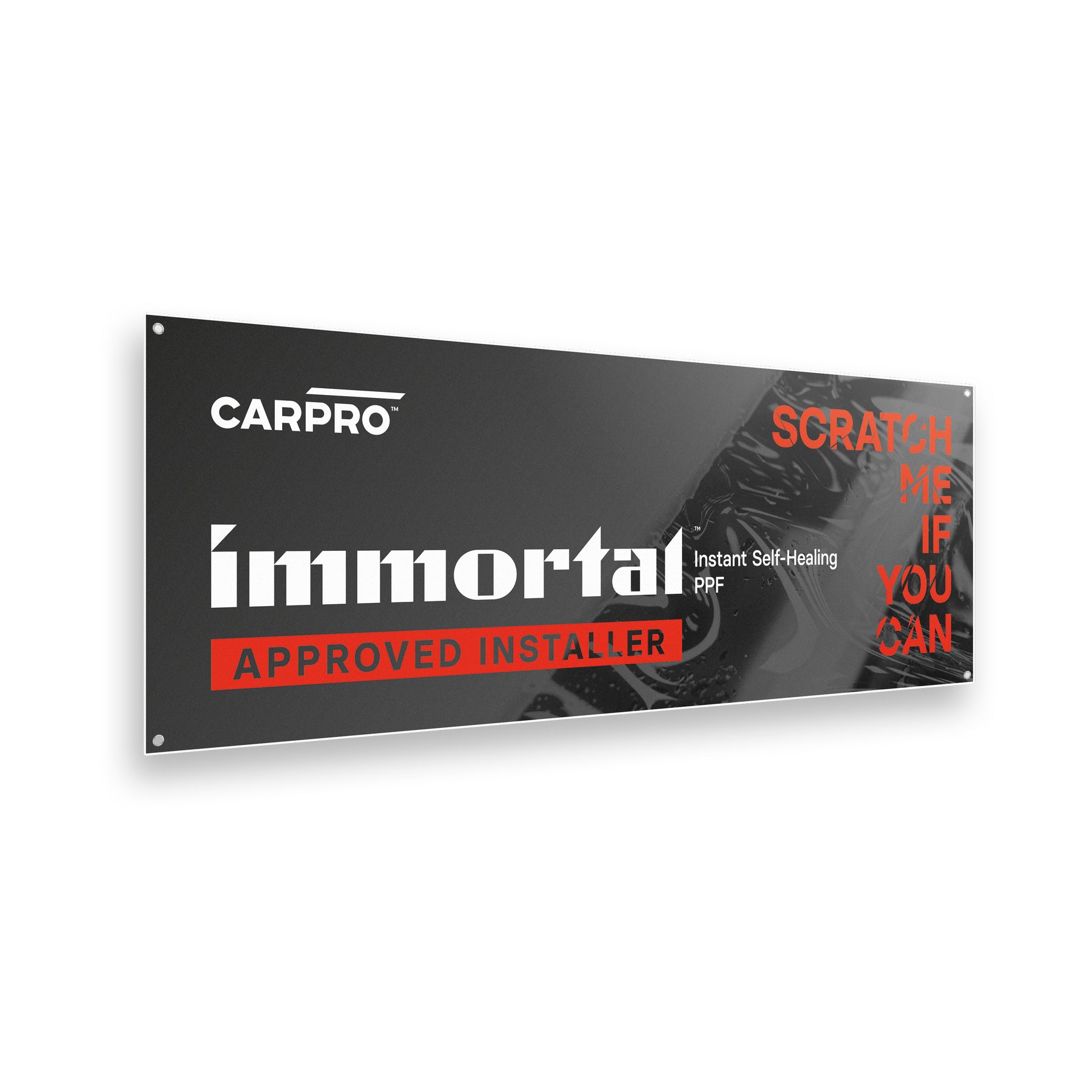 secondo banner del set CARPRO Immortal. Il design orizzontale presenta il logo CARPRO in bianco a sinistra, il testo "Immortal Approved Installer" in bianco e rosso al centro e "Scratch Me If You Can" in rosso a destra. Sullo sfondo c'è un'immagine dettagliata di una superficie lucida, enfatizzando il tema del prodotto. Questo banner è ideale per decorare e personalizzare spazi di lavoro, dando un tocco professionale e accattivante.
