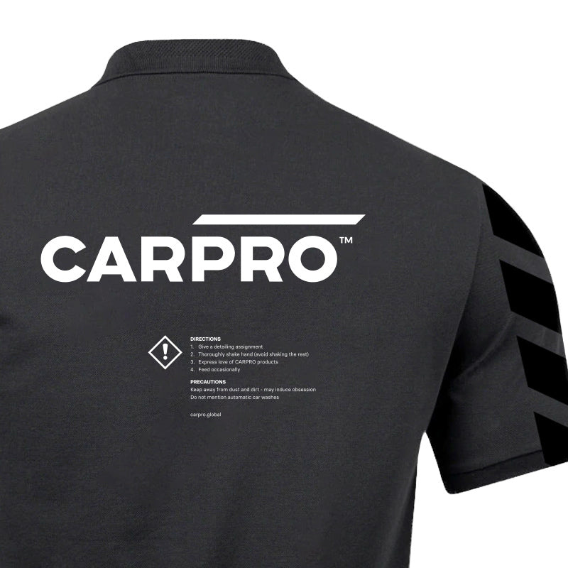 Retro della polo nera CARPRO con grande logo bianco e dettagli sulle istruzioni di utilizzo, perfetta per i professionisti del detailing.
