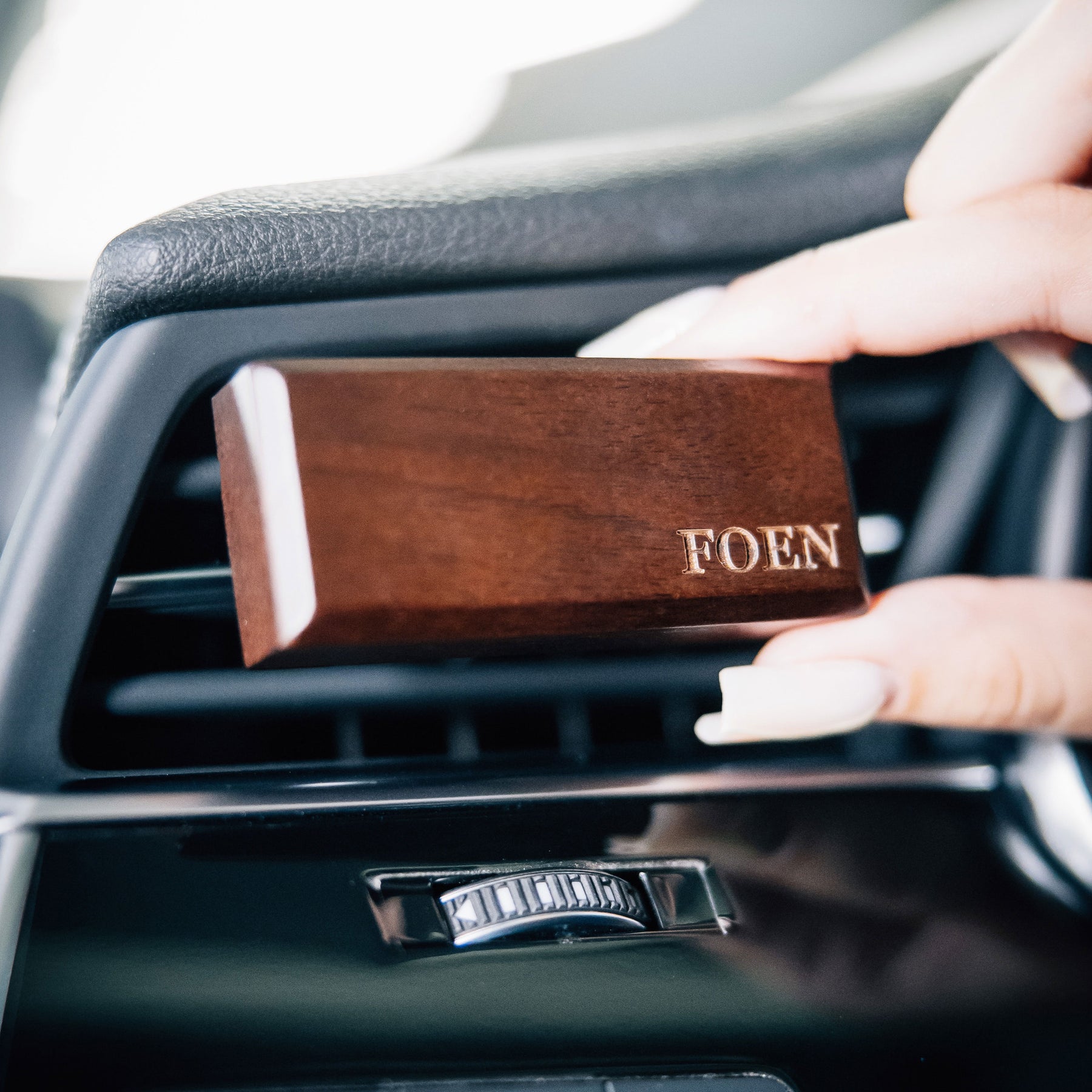 Diffusore FOEN Wood Stick in legno installato nella bocchetta dell’aria dell’auto, design elegante per profumazione agrumata e naturale.