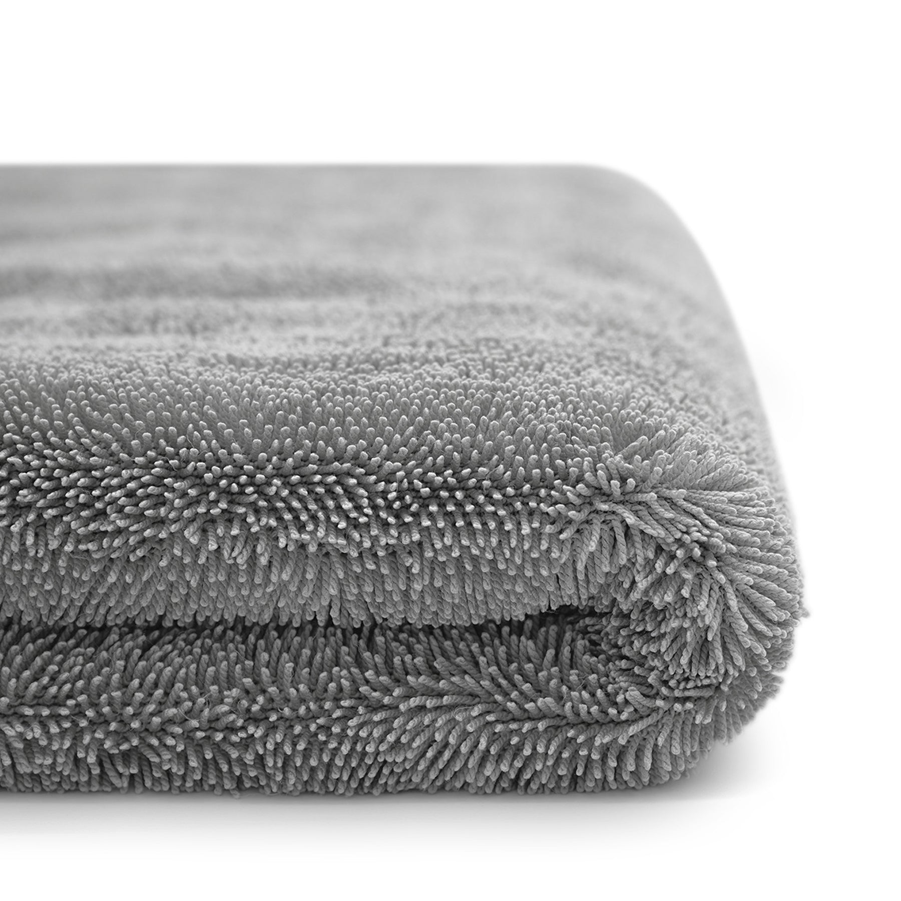 Vista laterale di un panno in microfibra grigio, piegato e ultra assorbente, ideale per asciugare l'auto senza lasciare segni o graffi.
